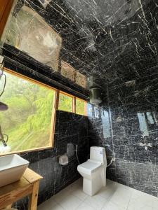 y baño con aseo blanco y lavamanos. en Kakapo Nest By Woodoo Treehouse and Cottages, en Jibhi
