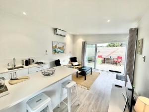 une cuisine et un salon avec une table et des chaises dans l'établissement Sailor's Cottage - Stay Waiheke, à Blackpool