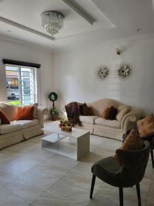 a living room with two couches and a table at Dvyne Luxury Home in Ikeja