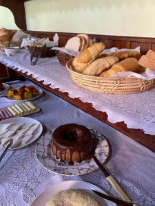 a table topped with baskets of bread and pastries at Chalés Del Rincon in Monte Verde