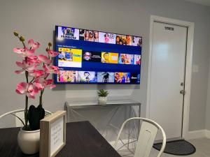 a living room with a tv on a wall at Bens Lavish Mini Luxury Suite in Fort Lauderdale
