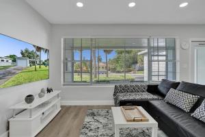 un soggiorno con divano nero e finestra di The Front Wave Luxury Home a Fort Lauderdale