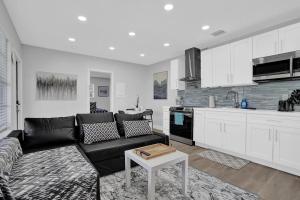 un soggiorno con un divano nero e una cucina di The Front Wave Luxury Home a Fort Lauderdale Altre 21 foto