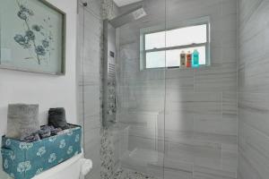 un bagno con doccia con porta in vetro di The Front Wave Luxury Home a Fort Lauderdale