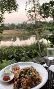 um prato de comida numa mesa com vista para um campo em Sunrise Riverside Pool Hostel em Luang Prabang