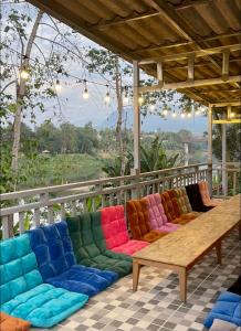 un grupo de coloridos sofás sentados en un porche en Sunrise Riverside Pool Hostel, en Luang Prabang