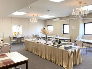 uma grande sala com mesas e cadeiras e lustres em Hotel Royal Kitami - Vacation STAY 04905v em Kitami