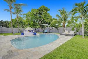 a swimming pool in a yard with palm trees at Yehudas Tropical Villa with Heated Infinity Pool in Hollywood