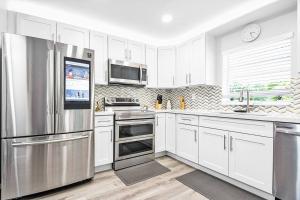 a kitchen with white cabinets and stainless steel appliances at Rachaels Upscale Two Bedrooms Luxury Home in Fort Lauderdale
