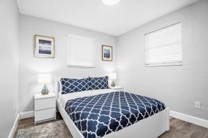 a bedroom with a bed and two windows at Rachaels Upscale Two Bedrooms Luxury Home in Fort Lauderdale
