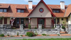 una casa con tetto rosso e recinzione di Boróka Apartman Lenti a Lenti