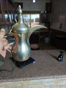 a person holding a tea pot on a counter at Jerash ruins hotel in Jerash