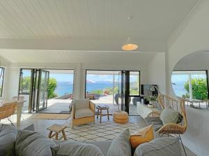 a living room with a couch and chairs at Sea View Estate - Waiheke Escapes in Onetangi