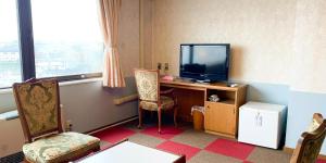 um quarto com uma secretária, uma televisão e uma cadeira em Hotel Royal Kitami - Vacation STAY 06513v em Kitami