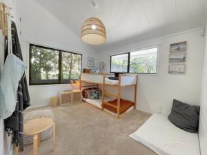 a living room with a desk and windows at Sea View Estate - Waiheke Escapes in Onetangi