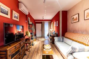 a living room with red walls and a white couch at Apartamento Mikaela Alcalá de Henares in Alcalá de Henares