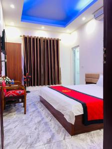 ein Schlafzimmer mit einem großen Bett mit einer roten Decke in der Unterkunft TITANIC 3 HOTEL in Hậu Dương