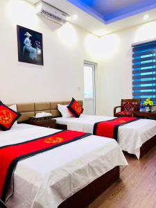 a room with three beds with red and white sheets at TITANIC 3 HOTEL in Hậu Dương