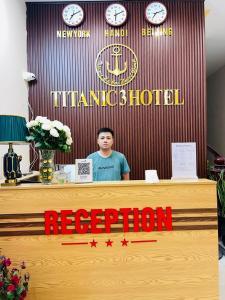 Hậu Dương的住宿－TITANIC 3 HOTEL，站在酒店接待台后面的人