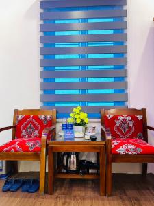 Hậu Dương的住宿－TITANIC 3 HOTEL，两张椅子,红色靠垫坐在桌子旁