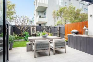 patio ze stołem, krzesłami i ogrodzeniem w obiekcie Coastal Cool Maroubra w mieście Sydney