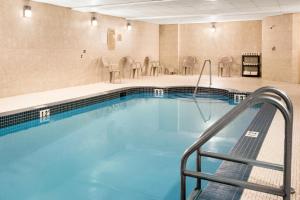 a pool in a hotel room with a swimming pool at Days Inn & Suites by Wyndham Cochrane in Cochrane