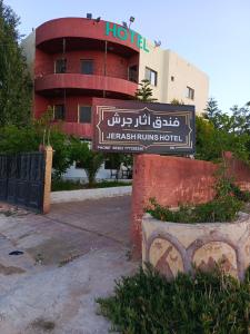 um sinal para um hotel em frente a um edifício em Jerash ruins hotel em Gérasa