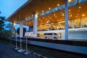 una furgoneta blanca estacionada frente a un edificio en ASTON Banua Banjarmasin Hotel & Convention Center, en Banjarmasin