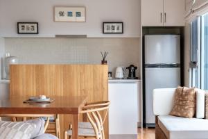 a kitchen with a table and a refrigerator at Sea View ~ ultimate beachside retreat! in Coles Bay