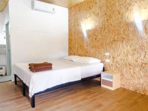 Lux Guesthouse في جزيرة في في: غرفة نوم بسرير ابيض وجدار بارضية خشبية