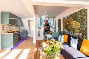 a living room with a blue couch and a kitchen at The Breakers - Riviera Apartment in Sandgate