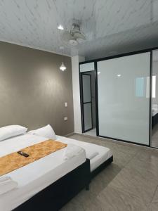two beds in a room with a large window at HOSPEDAJE EL ENSUEÑO in Doradal