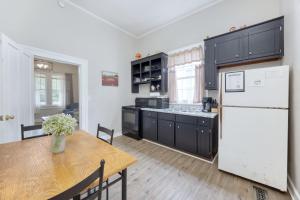a kitchen with a table and a white refrigerator at The Chattahoochee Cottage Walk to River & Shops in Columbus