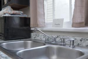 a kitchen sink and a window with a sign on it at The Chattahoochee Cottage Walk to River & Shops in Columbus +19 photos