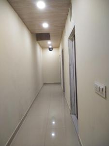 un corridoio vuoto di un edificio adibito a uffici con corridoio di OYO Diamond Guest House a Rudrapur