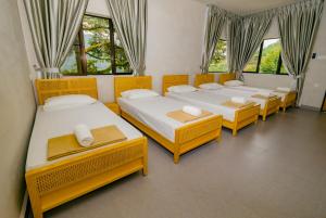 a group of four beds in a room with windows at Hillcrest Dawn, Bentong in Bentong +40 photos