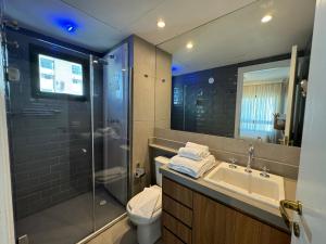 uma casa de banho com um lavatório, um chuveiro e um WC. em Comfort Flat Pinheiros em Hotel 4,5 estrelas em São Paulo