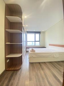 a bedroom with a bed and a book shelf at Hi-Home - City view apartment in HongKong Tower in Hanoi