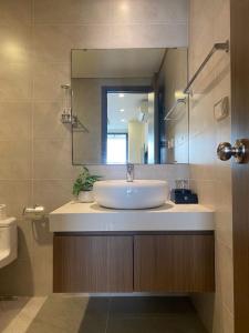 a bathroom with a sink and a mirror at Hi-Home - City view apartment in HongKong Tower in Hanoi