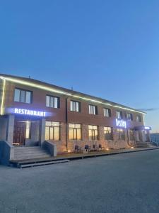 a building with a sign that reads restaurant on it at Destiny Hotel in Harhorin
