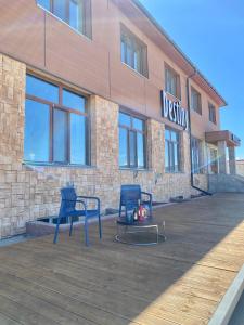 two blue chairs sitting in front of a building at Destiny Hotel in Harhorin +26 photos