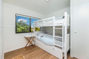 een slaapkamer met een stapelbed en een raam bij Sunset Sanctuary- Waiheke Escapes in Omiha