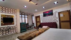 Großes Zimmer mit einem Bett und einem TV. in der Unterkunft SPOT ON Pachmarhi Hills in Pachmarhi