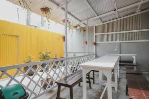 a balcony with a white table and a yellow wall at Take Guesthouse 1 in Jambi
