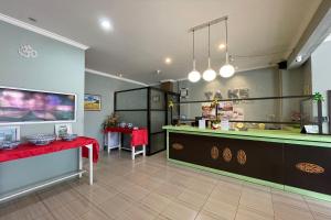 a kitchen with a counter and a red table in a room at Take Guesthouse 1 in Jambi