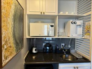 uma cozinha com um lavatório e um micro-ondas em Comfort Flat Pinheiros em Hotel 4,5 estrelas em São Paulo