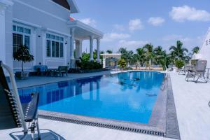 a swimming pool at a resort with blue water at M-Homey! Mini Resort in Mỹ Tho