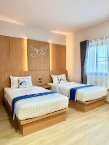 1 dormitorio con 2 camas y ventana en Air Diamond Hotel en Ban Nong Khong