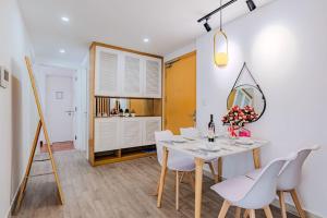 a dining room with a table and white chairs at Spacious 2 Bed Rooms Condo in Masteri Thao Dien in Ho Chi Minh City