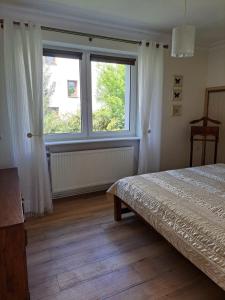 a bedroom with a bed and a large window at 75 m2 Apartment - Private House in Rumia
